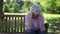 Depressed retired woman sitting on a bench