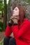 Depressed and sad young woman feeling depression sitting on forest, looking up with melancholic thinking