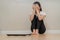 Depressed and stress, sad asian young woman,girl cover face with hand, sitting on floor, weighing on scale in front of her. Gain