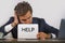 Depressed and stressed attractive hispanic man in suit and tie working overwhelmed office computer desk holding notepad asking for