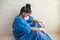 A depressed and tired Hispanic nurse wears a mask and gloves on the hospital floor