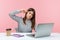 Depressed unhappy woman office worker in striped shirt sitting workplace showing stupid gesture to laptop display talking on video