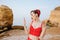 Depressed upset charming pinup girl in red swimsuit standing