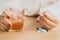 Depressed woman hand taking overdose pills with glass of alcohol