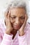 Depressed Woman Looking Unhappy Sitting On Side Of Bed At Home With Head In Hands