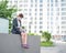 Depressed woman in medical mask sits on parapet outdoors with a box of personal items from the desktop. Unemployed girl