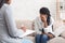 Depressed woman sitting on couch at psychotherapy session in coucellor`s office