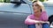 Depressed woman sitting near car