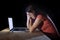 Depressed worker or student woman working with computer alone late night in stress