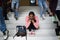 Depressed young student with face mask sitting on floor back at college or university, coronavirus concept.