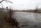 Depressive, ghostlike and foggy winters day in Czech nature. Panorama of a meadow with frosted pond in the foreground.