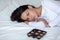 Depressive woman lying on bed near chocolate sweets feels lonely