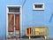 Derelict abandoned boarded up blue house with white broken door