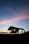 Derelict barn silhouette against beautiful vibrant sunset landscape