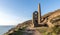 Derelict Cornish tin mine, on the cliff edge, against a blue sky