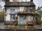 derelict house on a residential street with boarded up windows and decaying crumbling walls