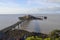 Derelict pier extending over rocky beach