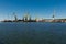 Derelict port cranes line harbor, symbolizing industrial decline. Unused loading equipment stands against clear sky