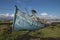 Derelict wooden fishing boat lies decaying on the shoreline of the Irish coast