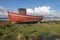 Derelict wooden fishing boat lies decaying on the shoreline of the Irish coast