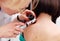 The dermatologist examines the moles or acne of the patient with a dermatoscope
