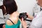 The dermatologist examines the moles or acne of the patient with a dermatoscope