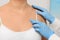 Dermatologist in rubber glove examining patient\'s birthmark on blurred background