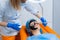 Dermatologist smears black mask on face for laser photorejuvenation and carbon peeling. Dermatology and cosmetology