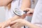 Dermatologist using professional magnifying glass while doing skin examination to female patient