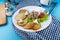 Deruny - potato pancakes with mushrooms, champignons, sour cream on a white plate. Cherry tomatoes, salad. Restaurant serving on a