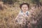 Desaturated photo of a baby boy in flowers in vintage style