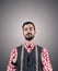 Desaturated portrait of young bearded hipster with hands pushed in his vest