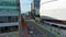 descending aerial footage along 16th Street with the Chase Center, a train crossing an intersection, red trees, office buildings