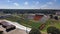 descending aerial footage of Eddie Robinson stadium with black and yellow writing on the field surrounded by lush green trees