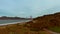 descending aerial footage of the Golden Gate Bridge over the Pacific ocean at Baker Beach with waves and people relaxing