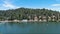 descending aerial footage of the green waters of Lake Gregory with a jungle gym on the water, boats, homes