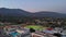 descending aerial footage of the Monrovia High School with a football field and a swimming pool surrounded by homes