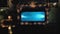 descending aerial footage of people swimming in a pool at a hotel at night with a brown wooden boardwalk with lights