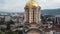 Descending drone footage of an orthodox church with Banja Luka cityscape in the background