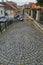 Descent on a city street laid out of tiles with patterns in the form of a circle going down. With nice houses and cars