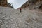 The descent of the tourist on the loose stones from the Forcella Staunies pass in the Dolomites