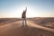 Desert adventure. Young man with backpack walking on sand dune. Dubai, United Arab Emirates