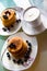 Desert with coffee, sweet pancakes topped with maple syrup and blueberries on the stylish plates, white cream coffee