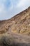 Desert dirt road ascending rocky hillside