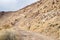 Desert dirt road ascending rocky hillside