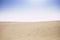 Desert dunes and blue sky landscape with no people - climate change and desertification concept with yellow sand and clear sky -