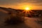 desert dunes, with the setting sun bringing warm and vibrant colors to the sky