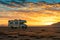 Desert Dusk: RV Embraces the Serene Sunset Horizon