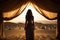 Desert Escape: Silhouette of Woman Embracing Golden Sands from Luxury Tent