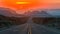 Desert highway at sunset, canyon silhouette against warm sky